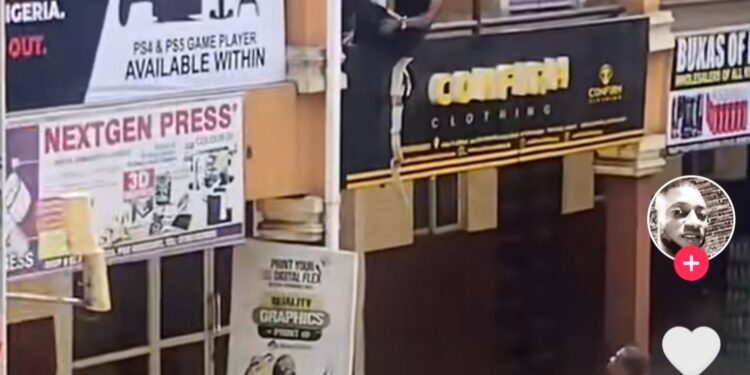 Suspected Yahoo Boy Evading Arrest Hangs Inbetween A Story Building (Video)