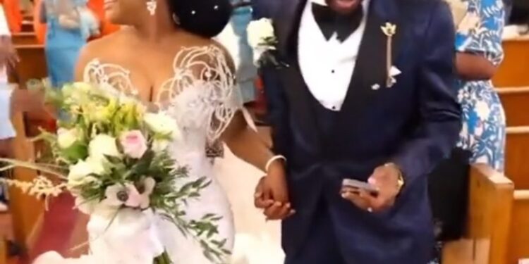 Nigerians React To Trending Video Of Groom Checking His Phone While Walking Down The Aisle With His Wife