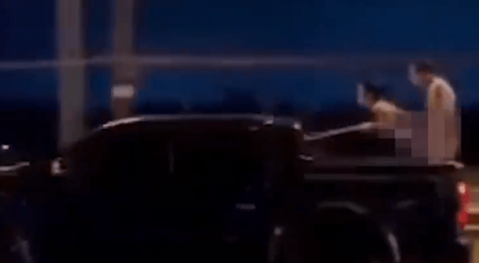 Shocking moment naked Russian couple have intercourse while standing in the back of a speeding truck (video)