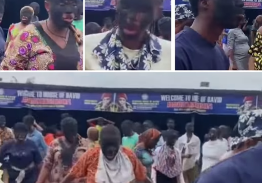 Church members cover their faces in charcoal as they pray during church program
