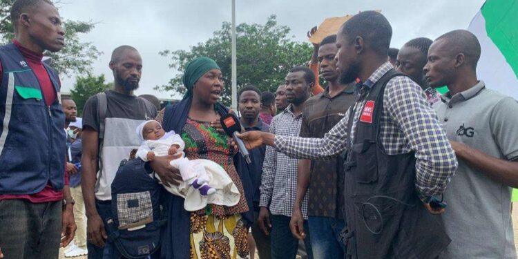 Nursing mother protests with her infant after her husband was killed by bandits