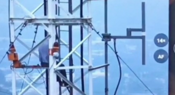 Abuja man threatens to jump from mast if subsidy isn’t restored (photos)